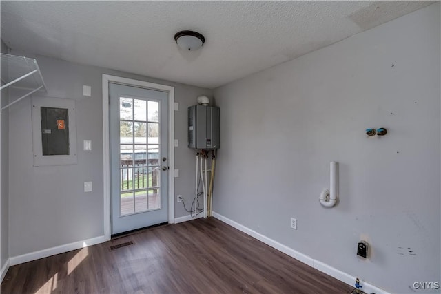 doorway featuring water heater, electric panel, dark wood-style flooring, and visible vents