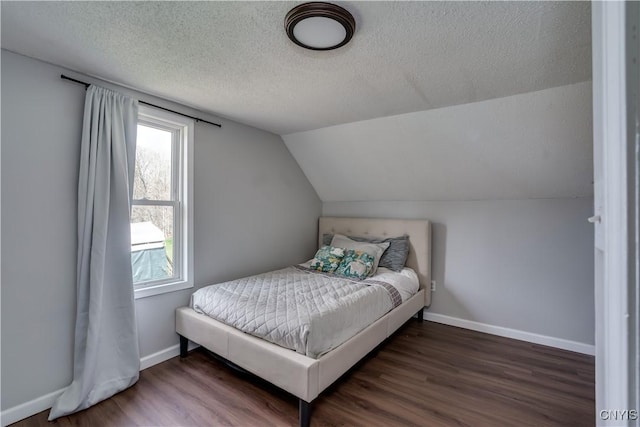 bedroom with a textured ceiling, multiple windows, and wood finished floors