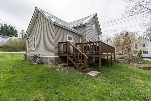 back of property with a lawn, stairs, a deck, and metal roof