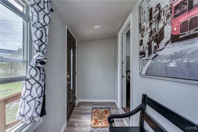 corridor with baseboards and wood finished floors