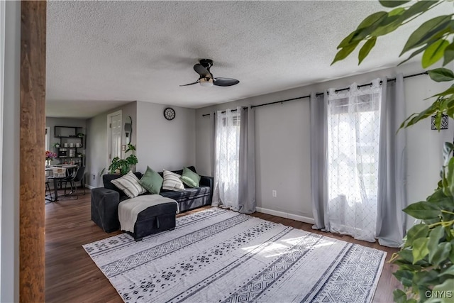 living room with a ceiling fan, a textured ceiling, and a wealth of natural light