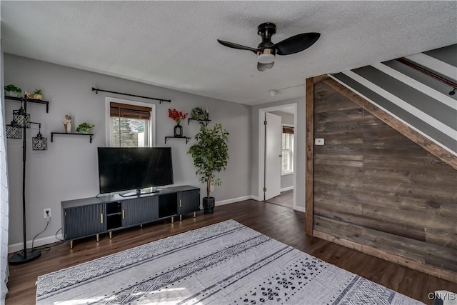 living room with a ceiling fan, a textured ceiling, a wealth of natural light, and wood finished floors