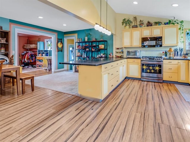 kitchen with black microwave, dark countertops, light wood finished floors, and stainless steel gas stove