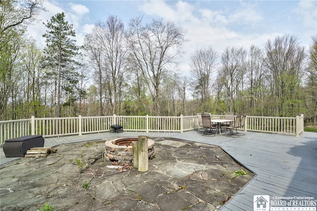 deck with outdoor dining area, a fire pit, and a patio area