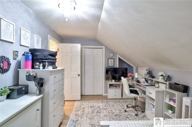 home office featuring light wood-type flooring and vaulted ceiling