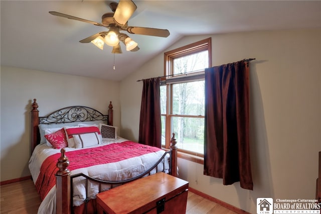 bedroom with light wood-type flooring, baseboards, ceiling fan, and vaulted ceiling