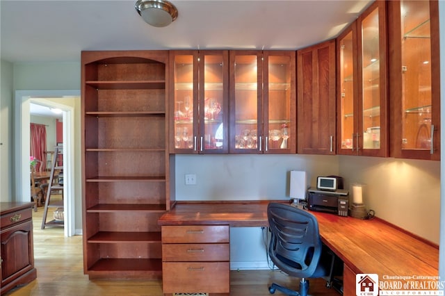 office space with built in desk and wood finished floors