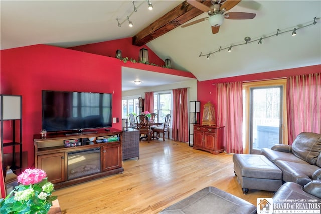 living area featuring vaulted ceiling with beams, rail lighting, ceiling fan, and light wood-type flooring