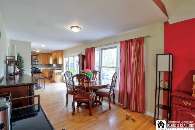 dining space featuring baseboards and light wood-style flooring