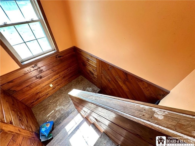 stairs featuring wood walls and a wainscoted wall