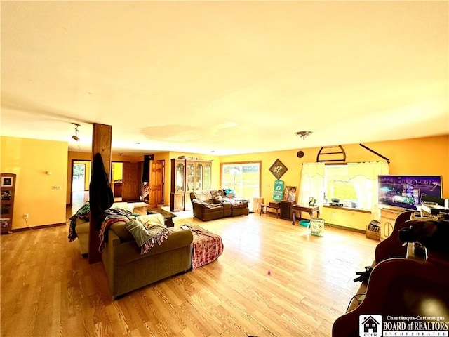 living area with baseboards and wood finished floors