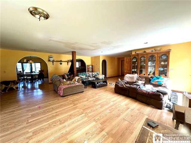 living room featuring arched walkways and wood finished floors