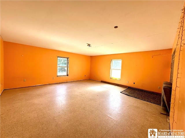 unfurnished room with tile patterned floors and baseboards