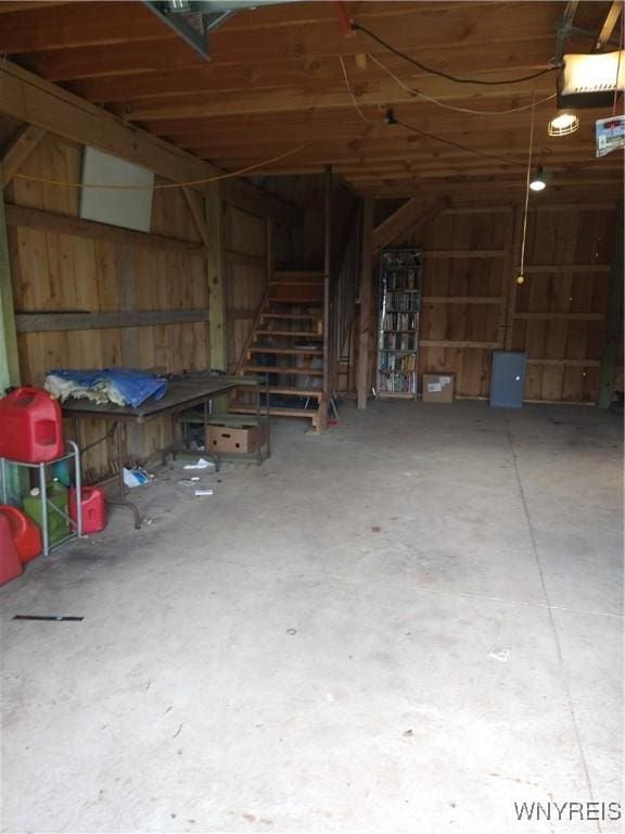 miscellaneous room with unfinished concrete flooring and a garage