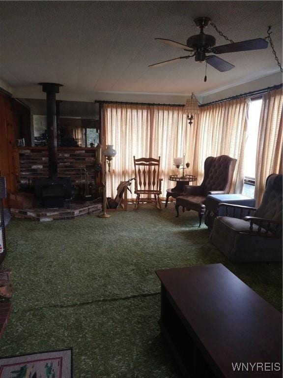 living room with ceiling fan, carpet, and a wood stove