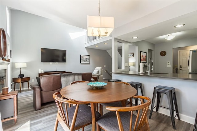 dining space with recessed lighting, baseboards, wood finished floors, and a fireplace