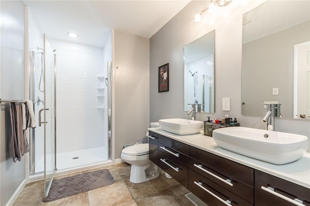 full bath with double vanity, toilet, a sink, and a stall shower