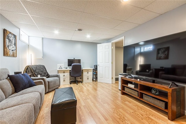 living area with light wood-style floors and a drop ceiling