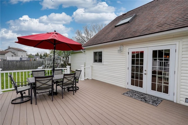 wooden deck featuring fence, french doors, and outdoor dining area