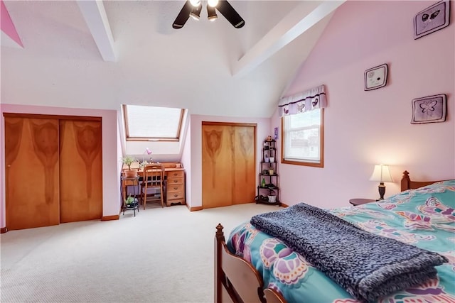 carpeted bedroom featuring vaulted ceiling with beams, two closets, and ceiling fan
