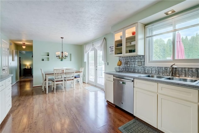 kitchen with wood finished floors, glass insert cabinets, white cabinets, a sink, and dishwasher