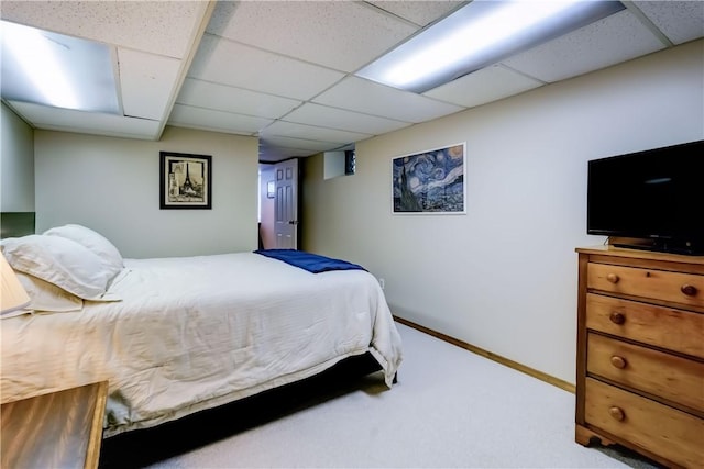 carpeted bedroom with baseboards and a paneled ceiling