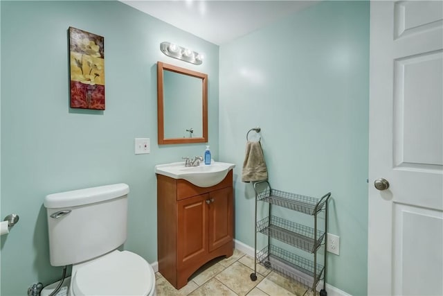 half bath with toilet, baseboards, tile patterned floors, and vanity