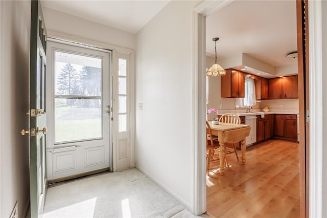 doorway featuring baseboards and light wood-style flooring