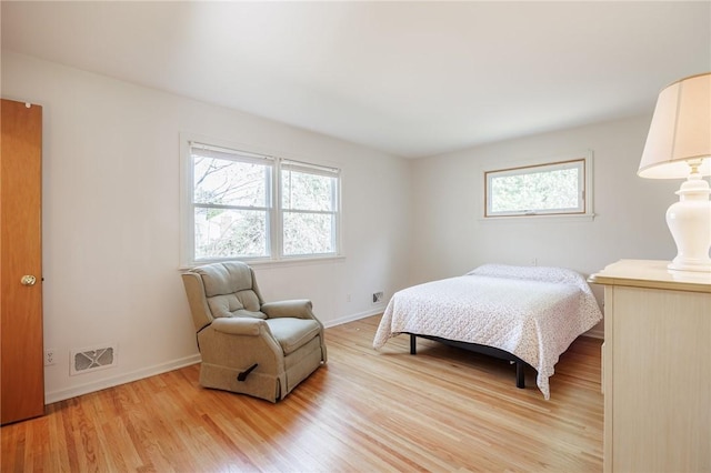 bedroom with visible vents, light wood-style flooring, baseboards, and multiple windows