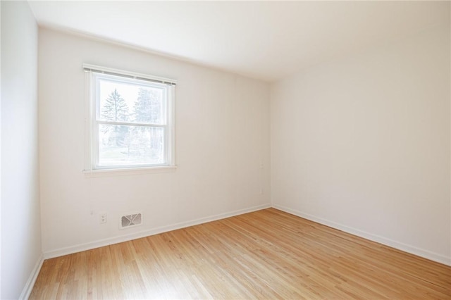 empty room with baseboards, visible vents, and light wood-style flooring