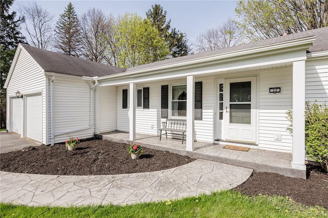 single story home with a porch, driveway, a shingled roof, and a garage