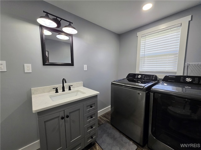 laundry room featuring baseboards, recessed lighting, separate washer and dryer, a sink, and dark wood finished floors