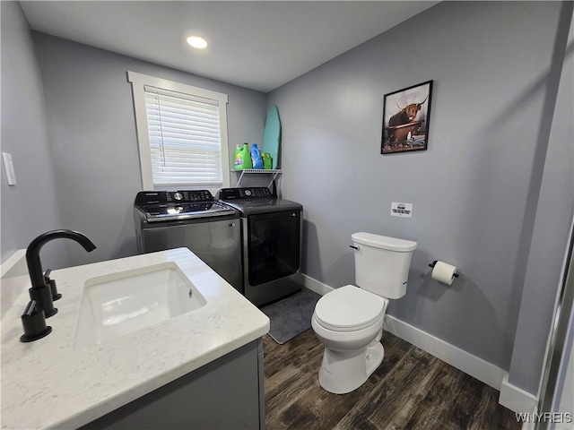 half bathroom featuring washing machine and dryer, wood finished floors, baseboards, toilet, and recessed lighting