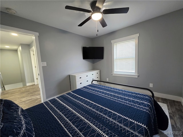 bedroom with baseboards, ceiling fan, and wood finished floors