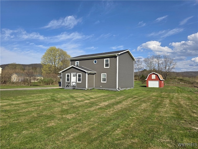 rear view of property featuring a barn, a yard, an outbuilding, and a detached garage