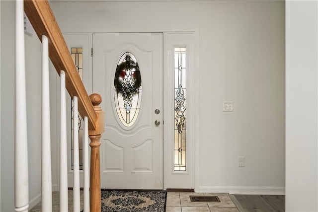 entrance foyer with baseboards, stairs, visible vents, and a wealth of natural light
