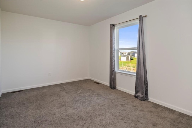 carpeted empty room featuring visible vents and baseboards
