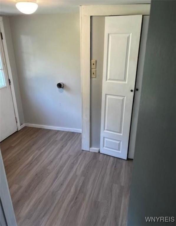 unfurnished bedroom featuring baseboards, a closet, and wood finished floors