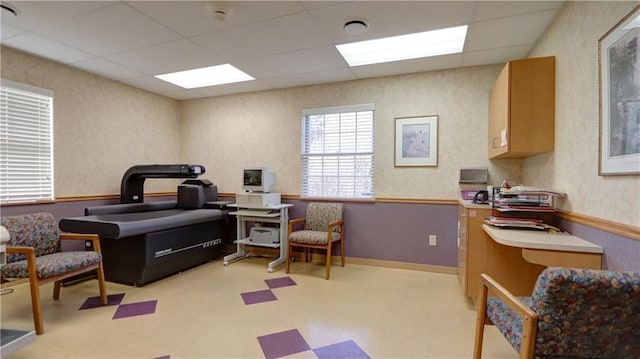 office space with wallpapered walls and a drop ceiling
