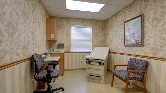 home office featuring a sink, a paneled ceiling, and wallpapered walls
