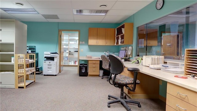 home office featuring built in study area, a drop ceiling, visible vents, and light colored carpet