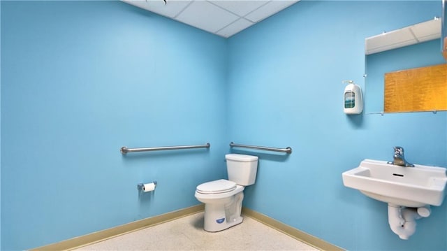 bathroom featuring toilet, baseboards, and a paneled ceiling