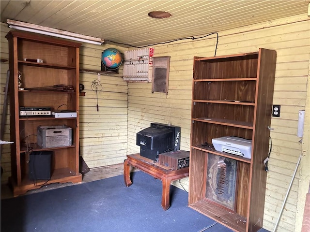 2384 State Highway 205, Laurens, NY 13810 - living area featuring wood ceiling, a wood stove, wood walls, and concrete flooring