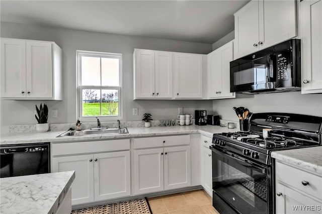kitchen with a sink, white cabinetry, and black appliances