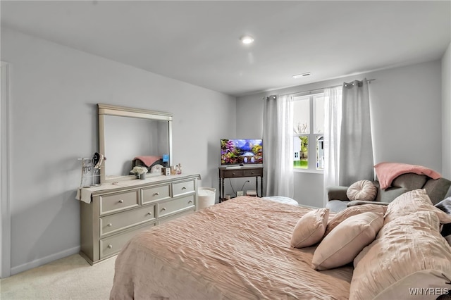 bedroom featuring baseboards, visible vents, and light carpet