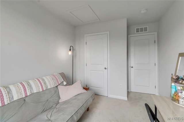 living area with baseboards, light colored carpet, attic access, and visible vents