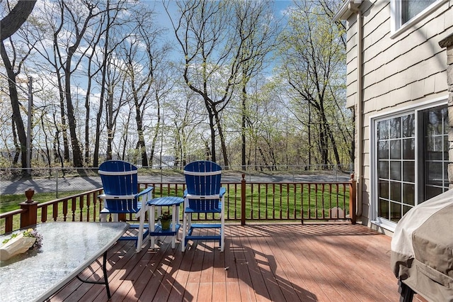 wooden terrace featuring fence and a yard