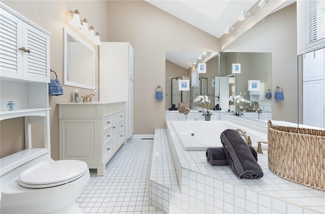 full bathroom with tile patterned flooring, vanity, a bath, rail lighting, and vaulted ceiling