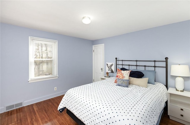 bedroom featuring visible vents, baseboards, and wood finished floors