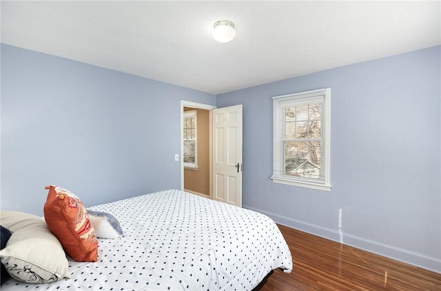 bedroom with baseboards and wood finished floors